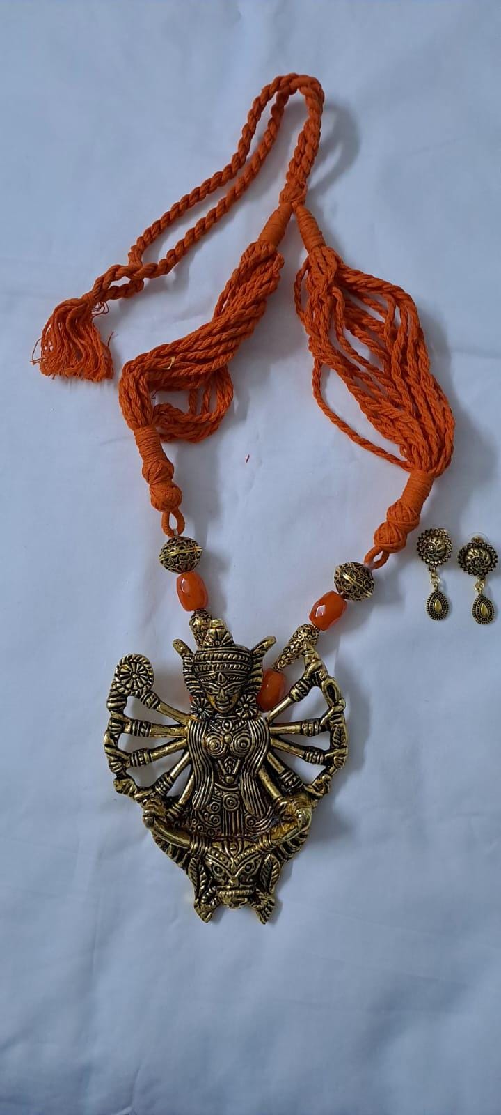 Orange thread necklace with oxidised golden durga pendant