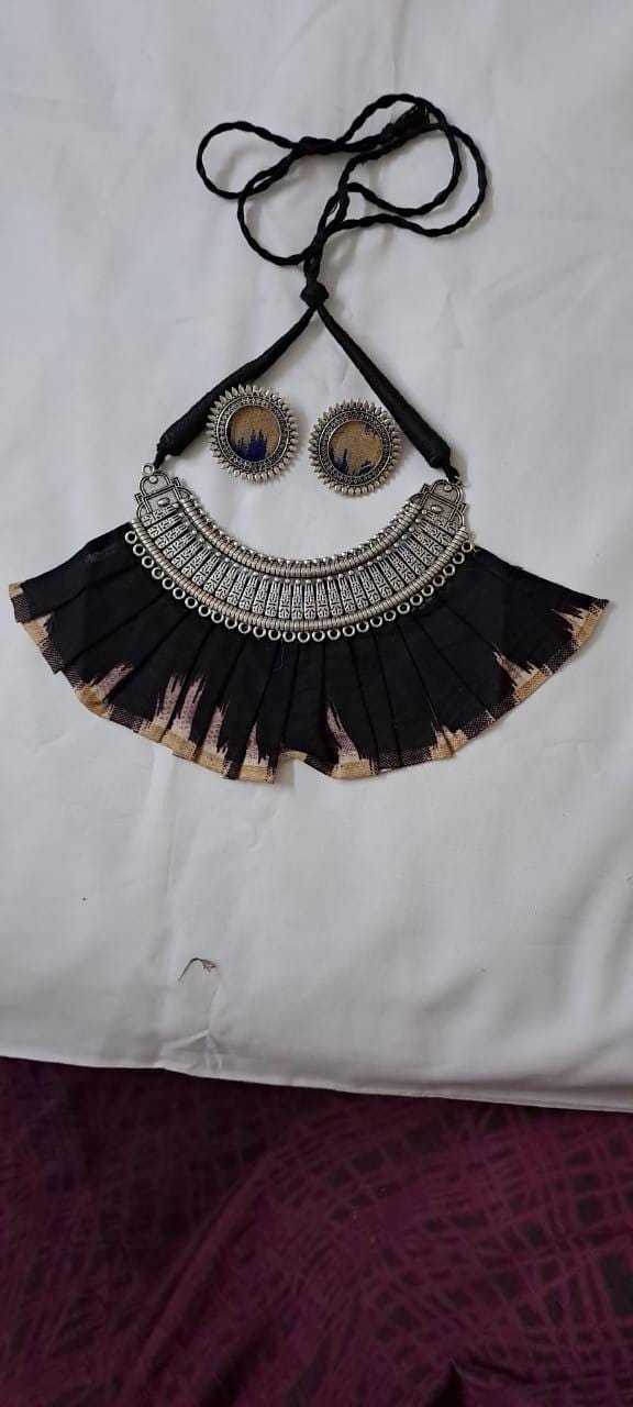 Exclusive necklace with silver oxidised big oval pendant with fabric fringes and matching earrings.