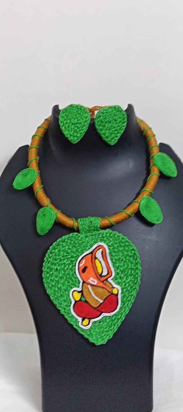 Exclusive light green and brown  thread necklace with leaf shaped  Ganesha pendant  and matching earrings.