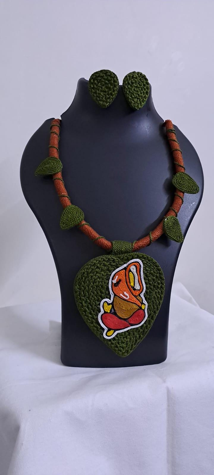 Exclusive forest green and brown thread necklace with leaf shaped  Ganesha thread pendant and matching earrings.