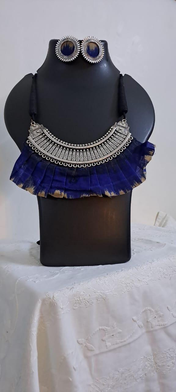 Exclusive necklace with silver oxidised big oval pendant with fabric fringes and matching earrings.