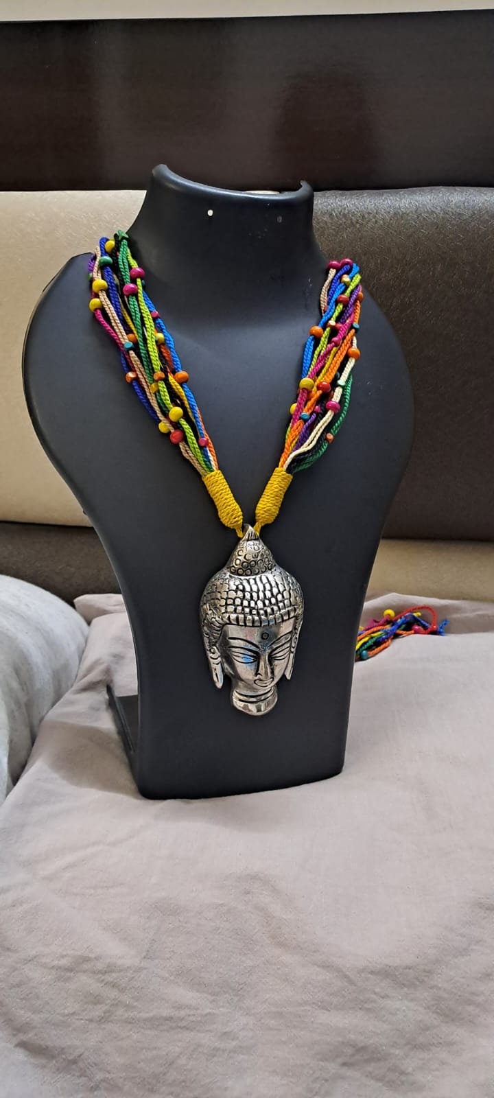 Multi coloured thread necklace with oxidised silver buddha pendant