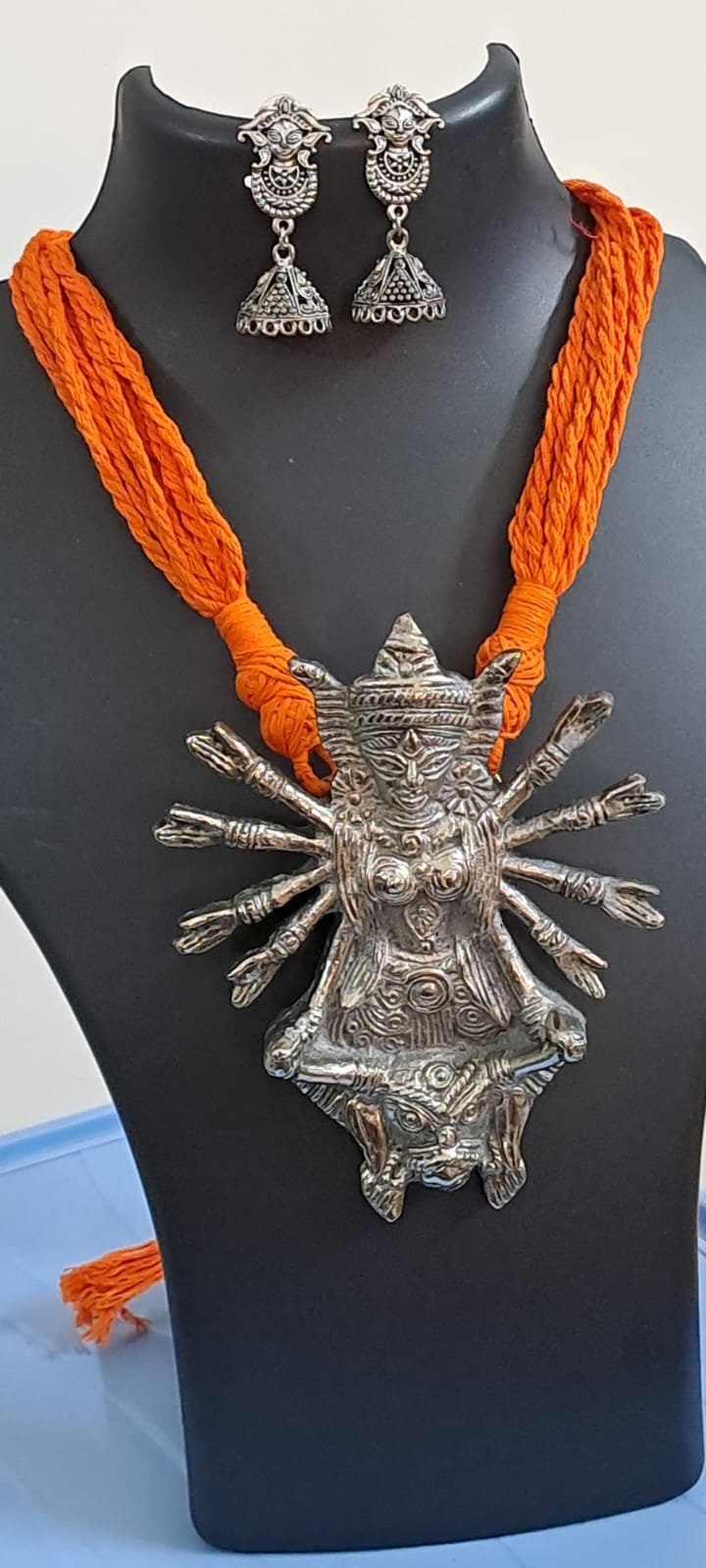 Orange thread necklace with oxidised silver durga pendant