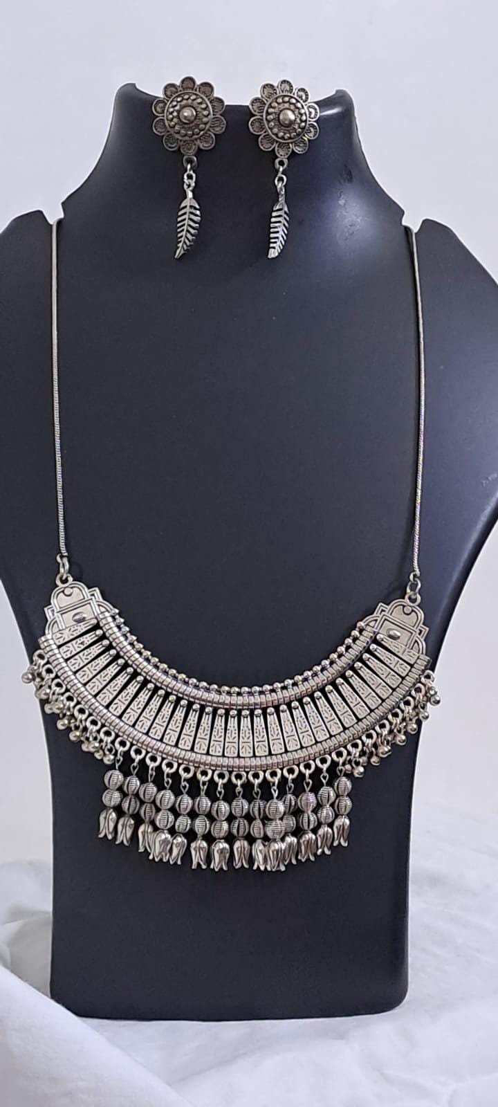 Exclusive necklace with silver oxidised big oval pendant with beads fringes and matching earrings.