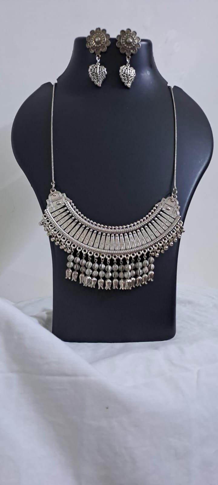 Exclusive necklace with silver oxidised big oval pendant with beads fringes and matching earrings.