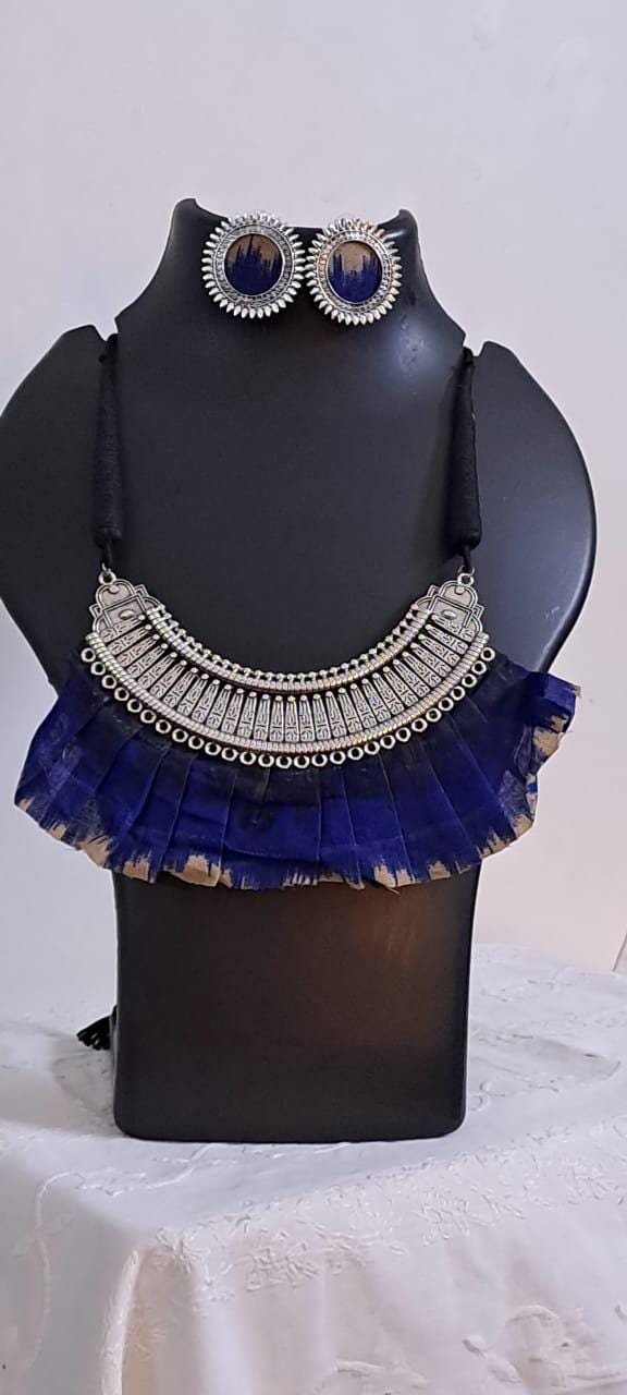 Exclusive necklace with silver oxidised big oval pendant with fabric fringes and matching earrings.