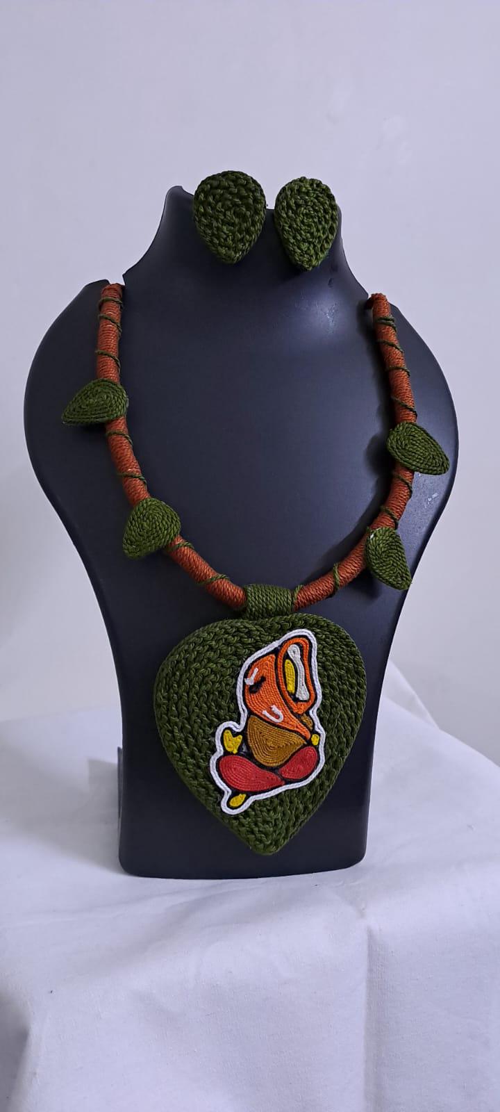 Exclusive forest green and brown thread necklace with leaf shaped  Ganesha thread pendant and matching earrings.