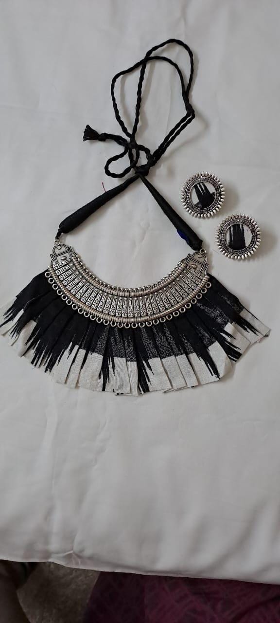 Exclusive necklace with silver oxidised big oval pendant with fabric fringes and matching earrings.