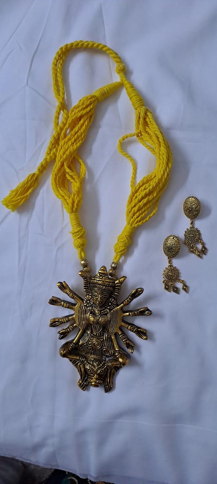 Yellow thread necklace with oxidised golden durga pendant