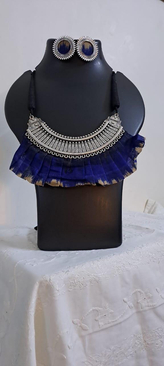 Exclusive necklace with silver oxidised big oval pendant with fabric fringes and matching earrings.