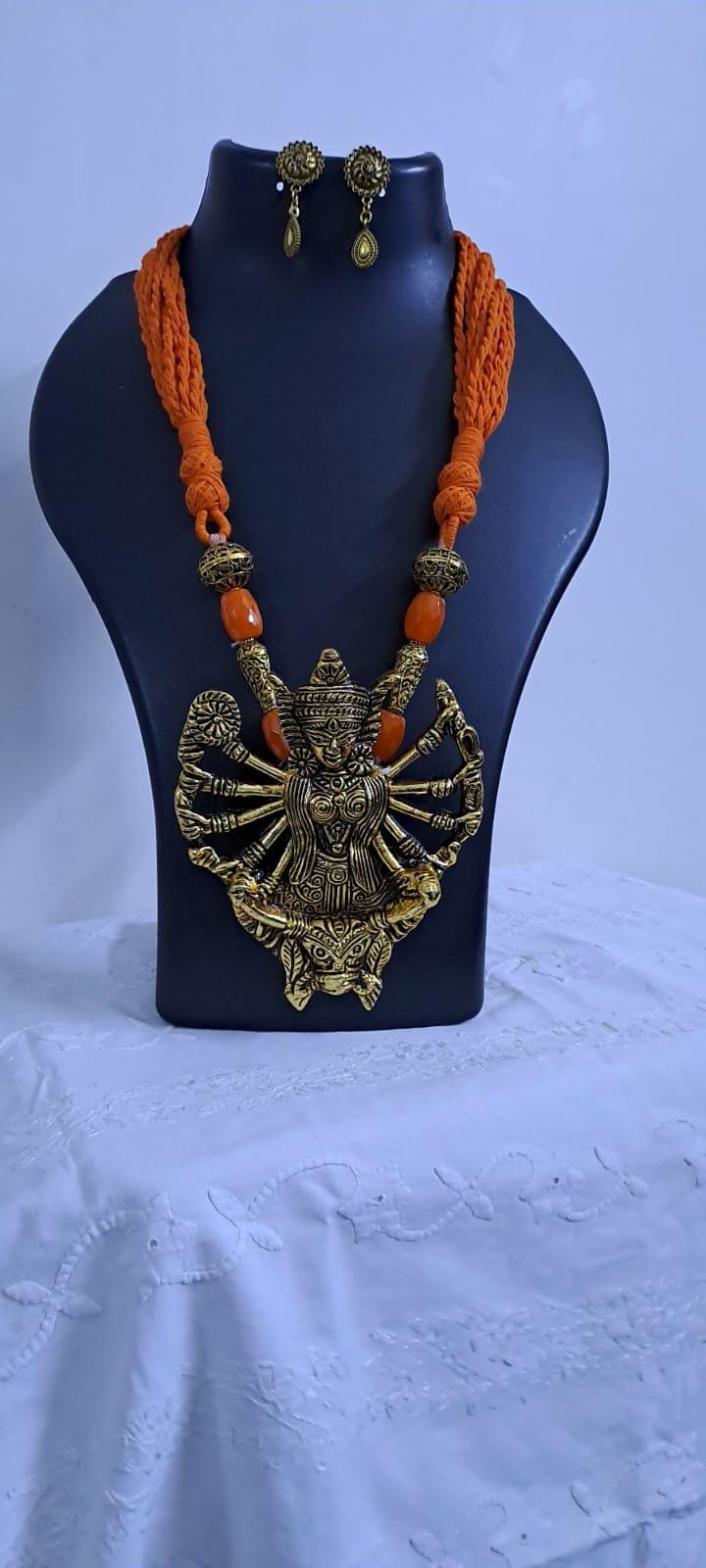 Orange thread necklace with oxidised golden durga pendant