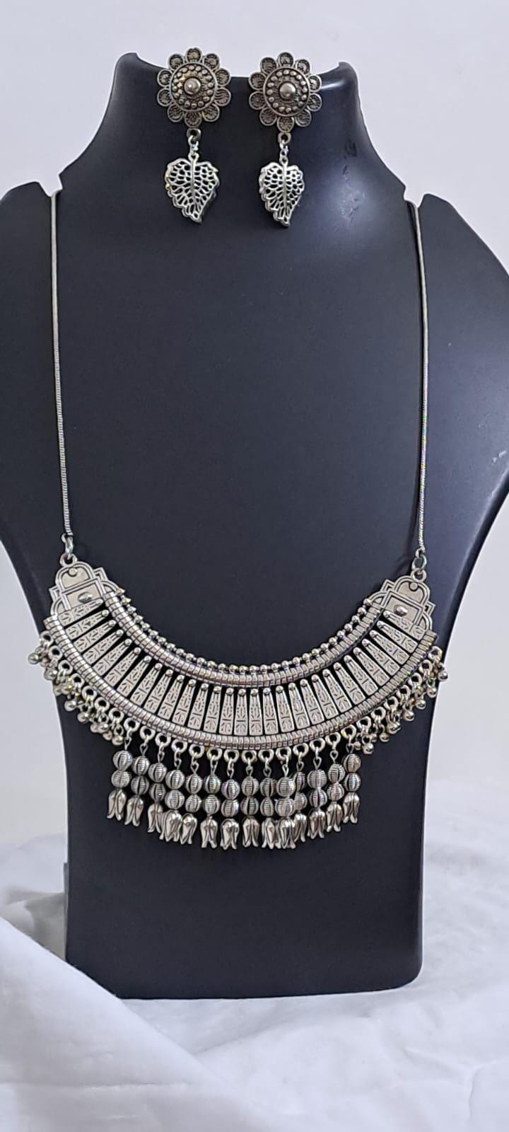 Exclusive necklace with silver oxidised big oval pendant with beads fringes and matching earrings.