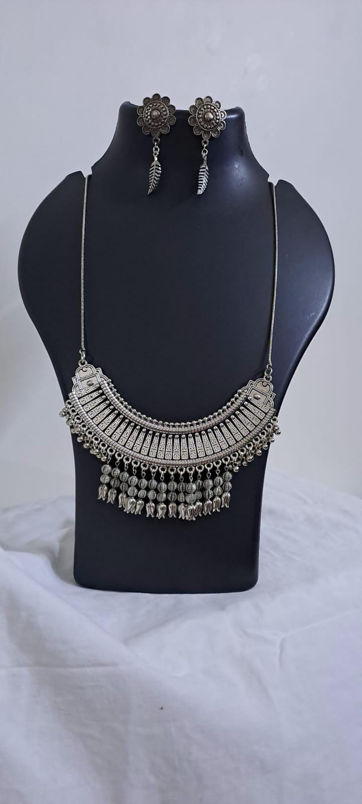 Exclusive necklace with silver oxidised big oval pendant with beads fringes and matching earrings.