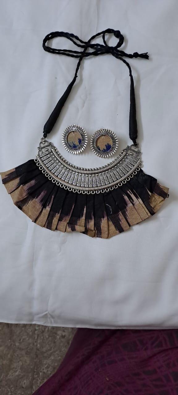Exclusive necklace with silver oxidised big oval pendant with fabric fringes and matching earrings.