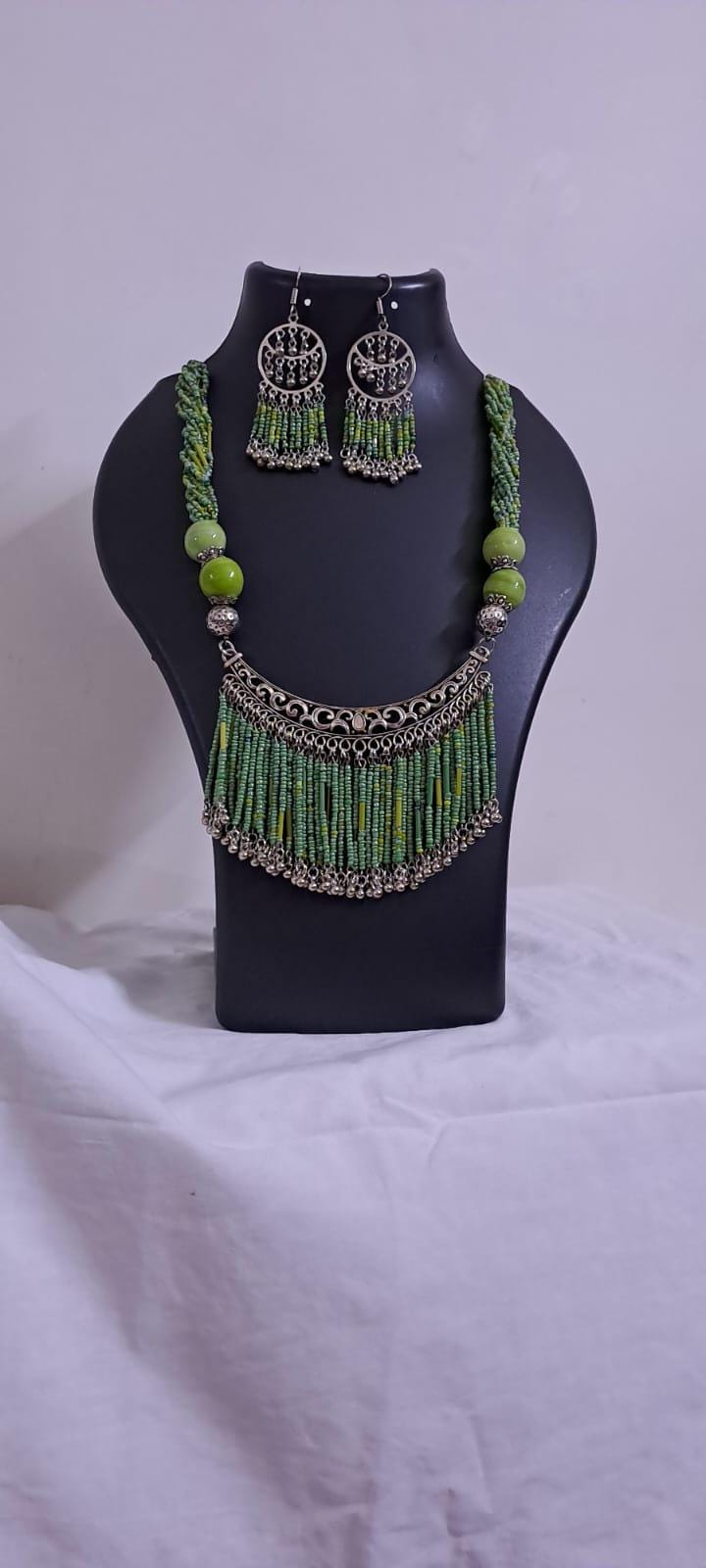 Exclusive necklace with silver oxidised big oval pendant with seed beads fringes and matching earrings.