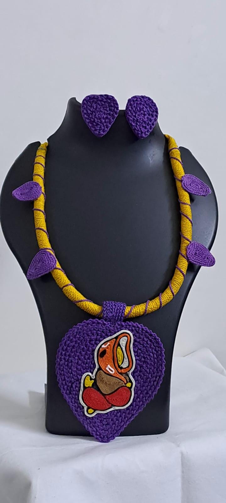 Exclusive yellow and purple thread necklace with leaf shaped  Ganesha thread pendant and matching earrings.