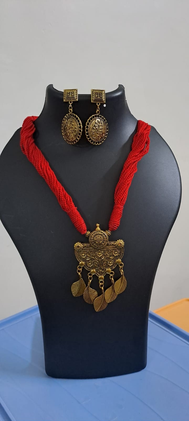 Red thread necklace with golden oxidised traditional pendant