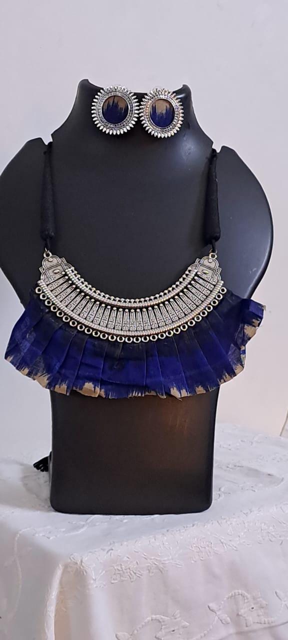 Exclusive necklace with silver oxidised big oval pendant with fabric fringes and matching earrings.