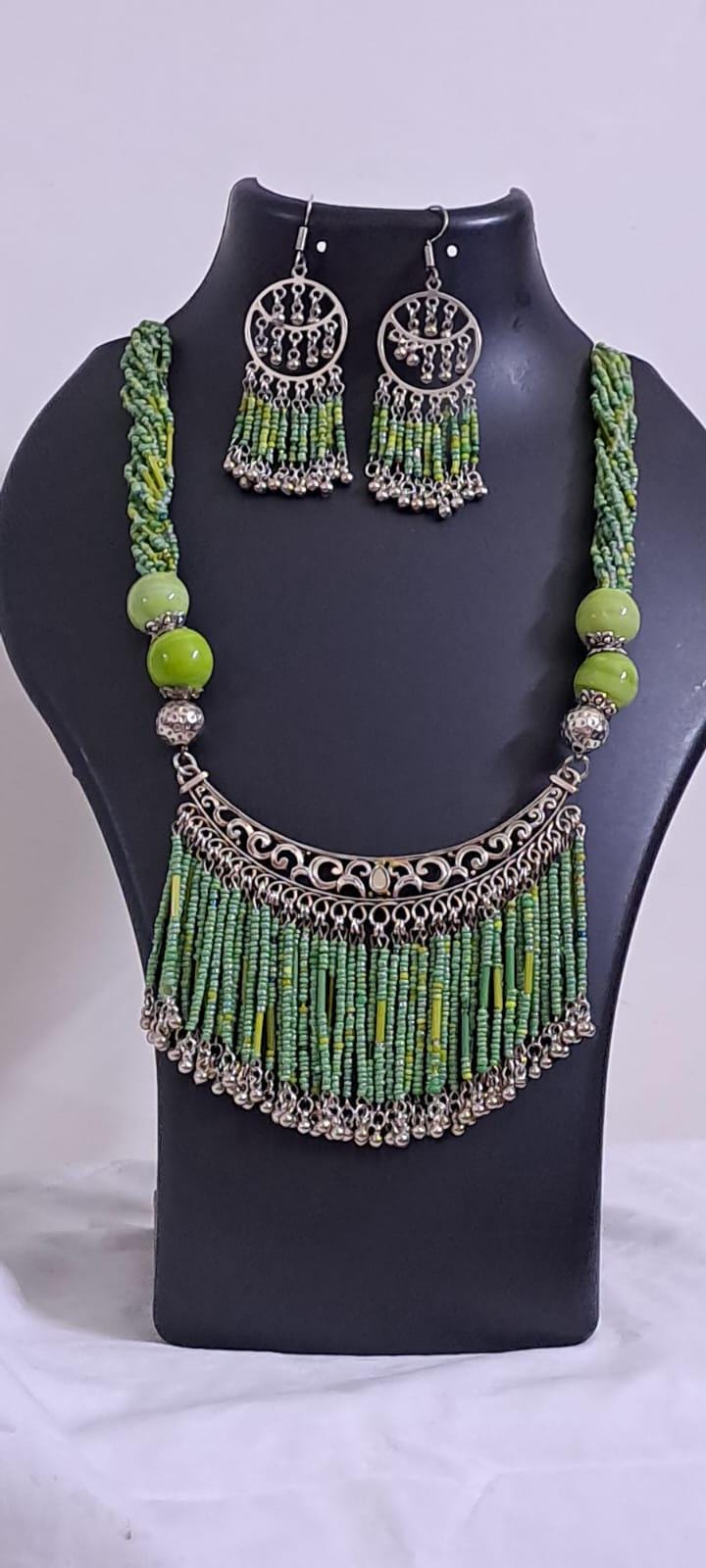 Exclusive necklace with silver oxidised big oval pendant with seed beads fringes and matching earrings.