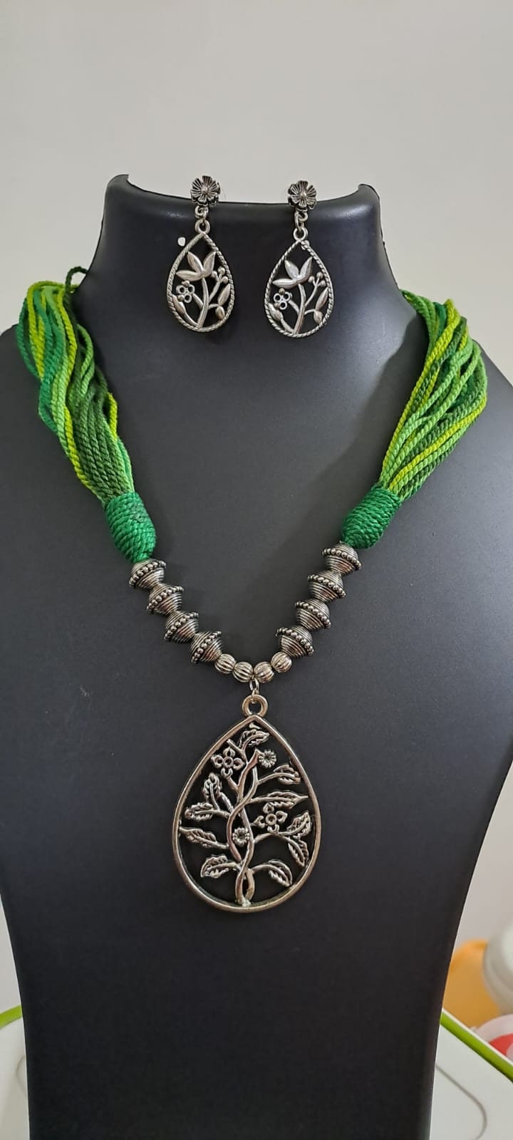 Green thread necklace with silver oxidised traditional pendant