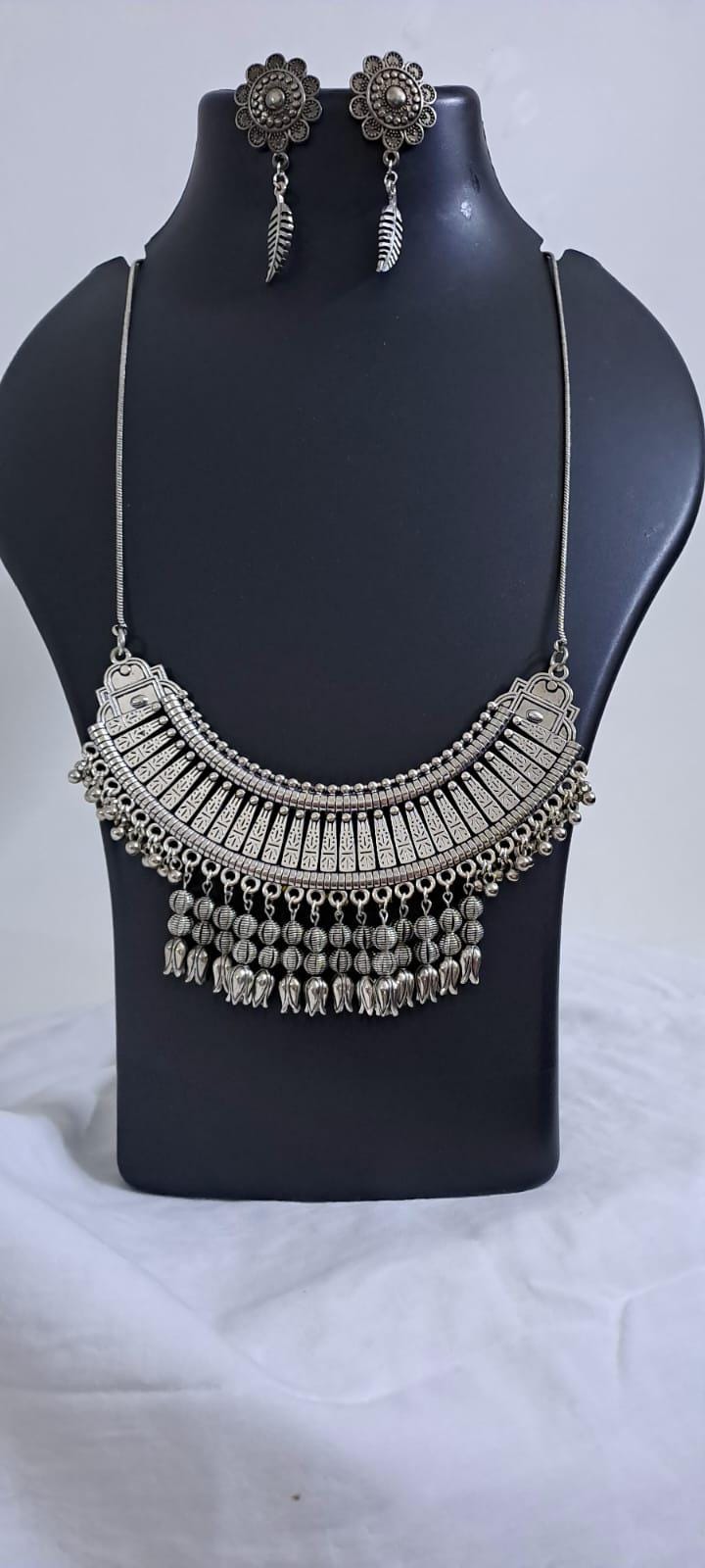 Exclusive necklace with silver oxidised big oval pendant with beads fringes and matching earrings.