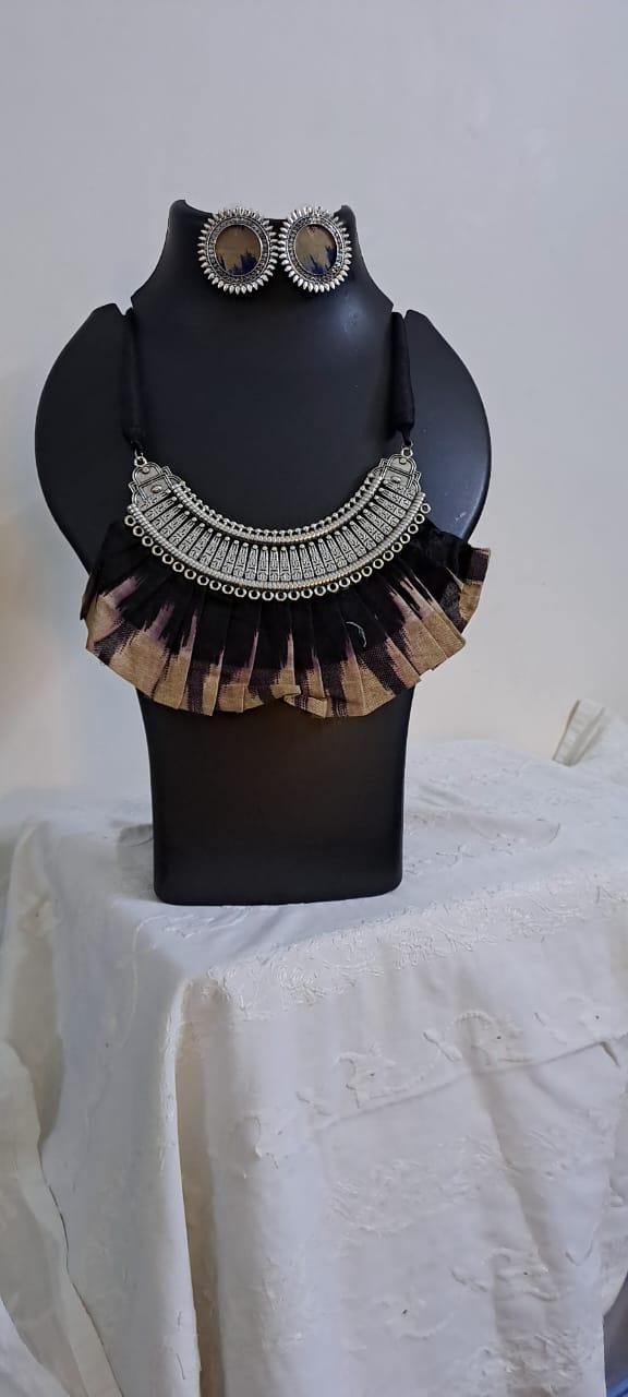 Exclusive necklace with silver oxidised big oval pendant with fabric fringes and matching earrings.