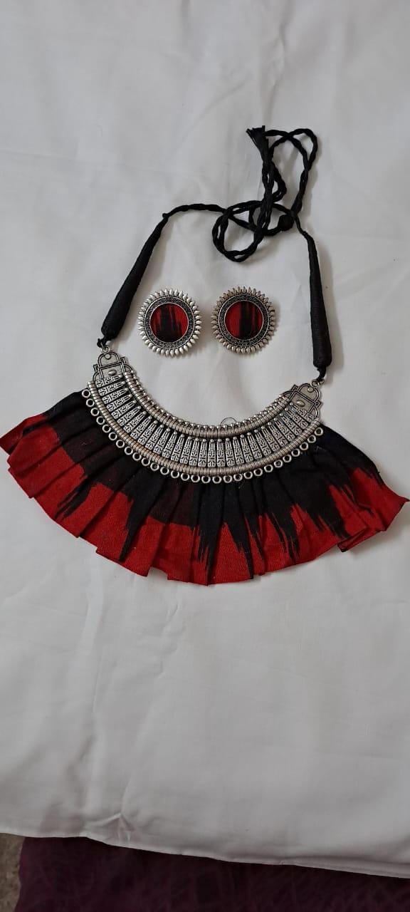 Exclusive necklace with silver oxidised big oval pendant with fabric fringes and matching earrings.