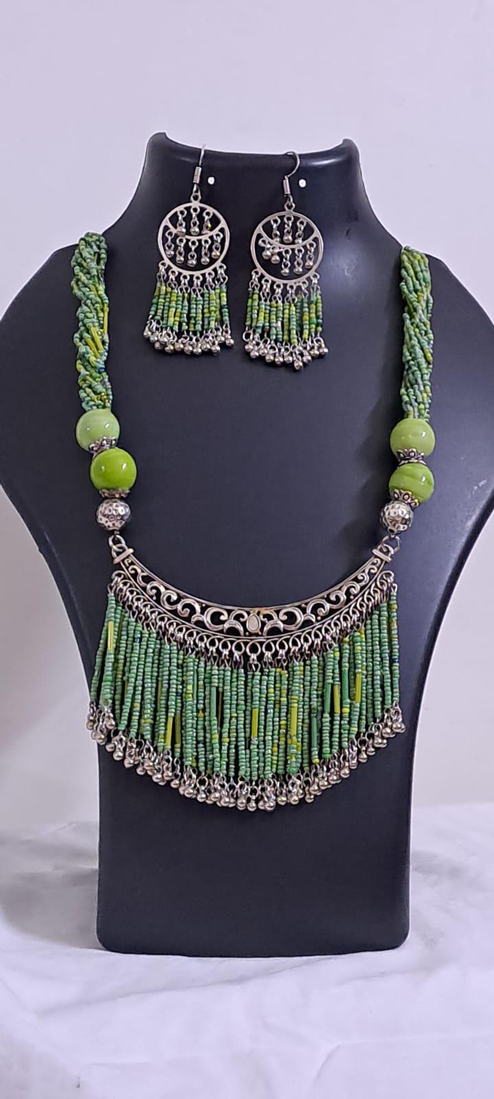 Exclusive necklace with silver oxidised big oval pendant with seed beads fringes and matching earrings.