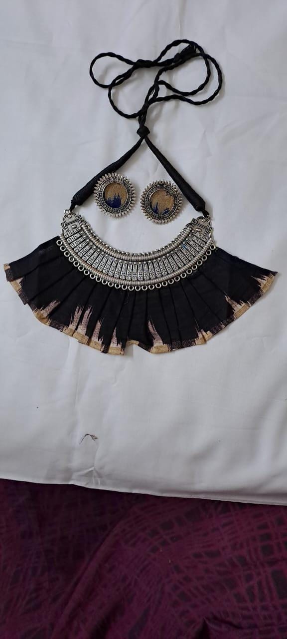 Exclusive necklace with silver oxidised big oval pendant with fabric fringes and matching earrings.