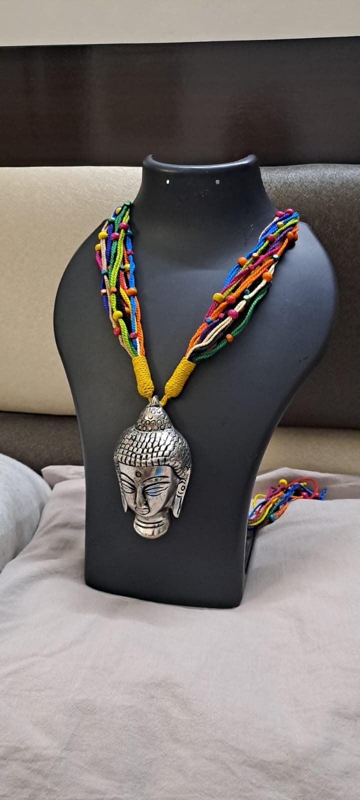 Multi coloured thread necklace with oxidised silver buddha pendant