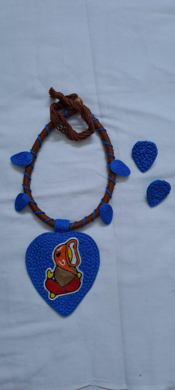 Exclusive brown and blue thread necklace with leaf shaped  Ganesha thread pendant and matching earrings.