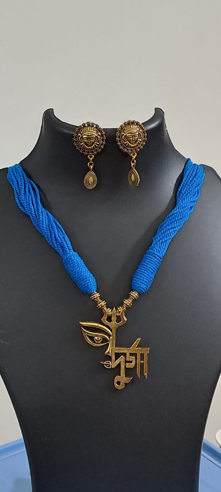 Blue thread necklace with oxidised golden durga pendant