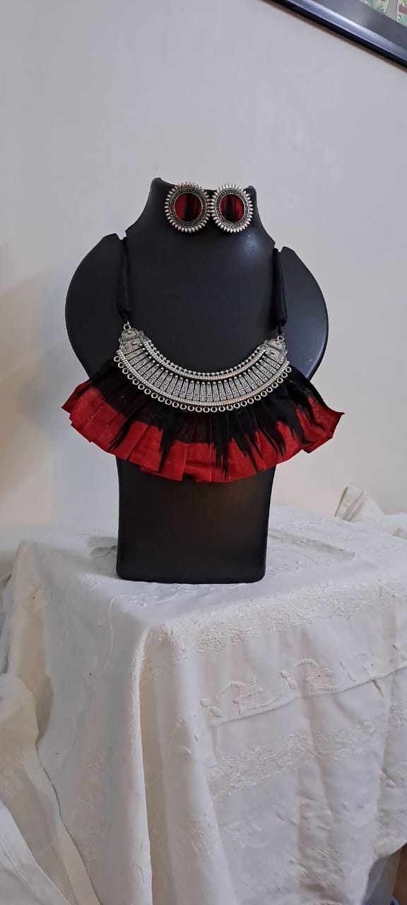 Exclusive necklace with silver oxidised big oval pendant with fabric fringes and matching earrings.