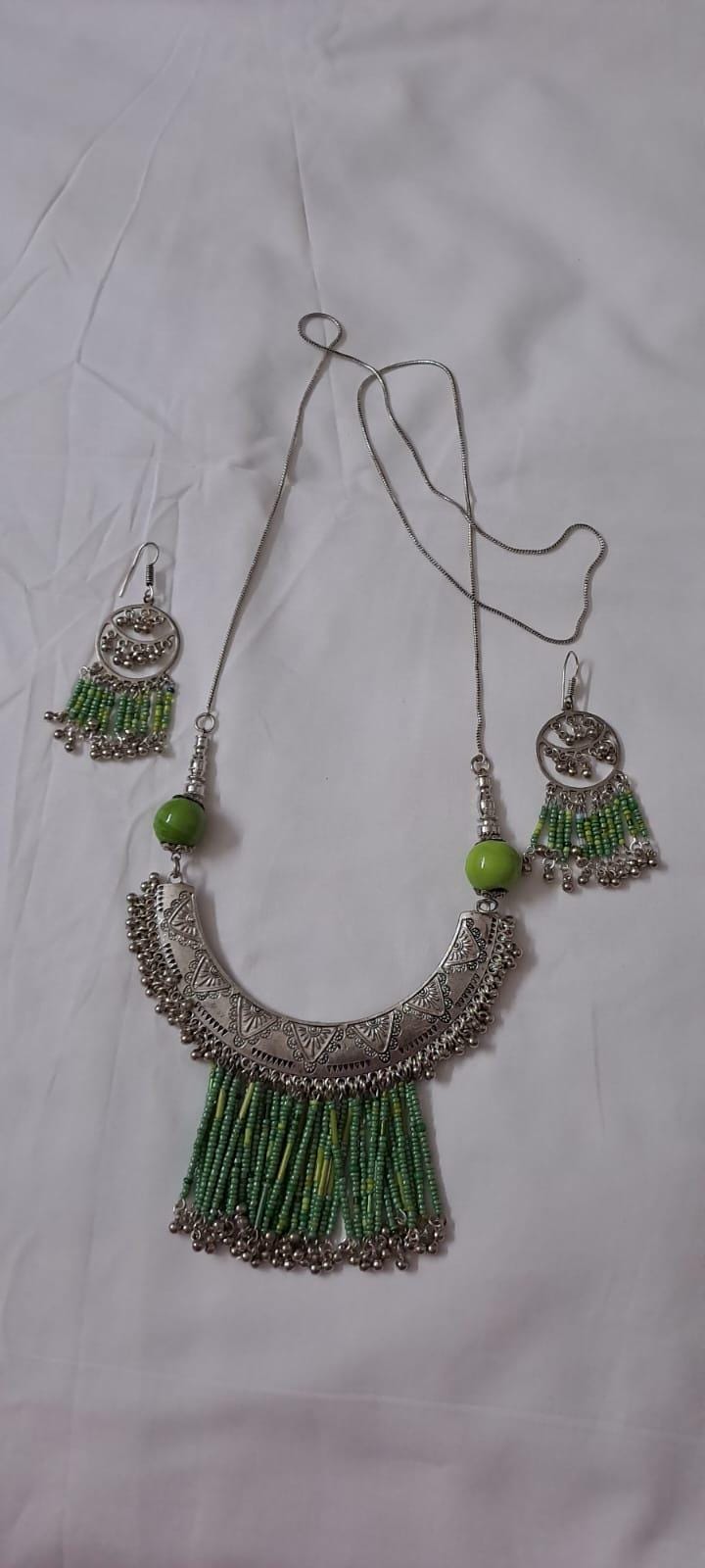 Exclusive necklace with silver oxidised big oval pendant with seed beads fringes and matching earrings.