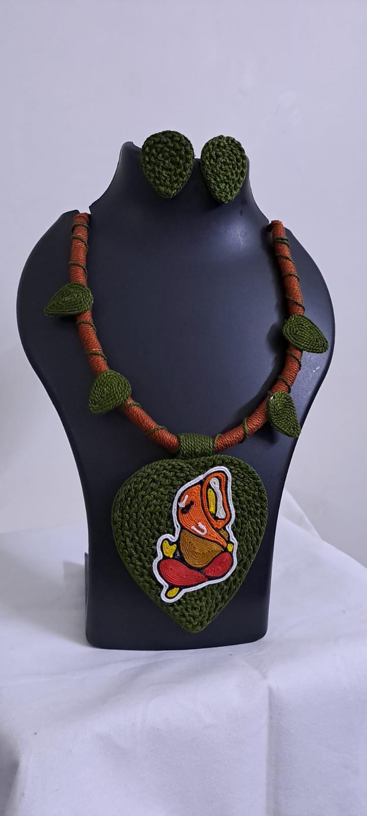 Exclusive forest green and brown thread necklace with leaf shaped  Ganesha thread pendant and matching earrings.