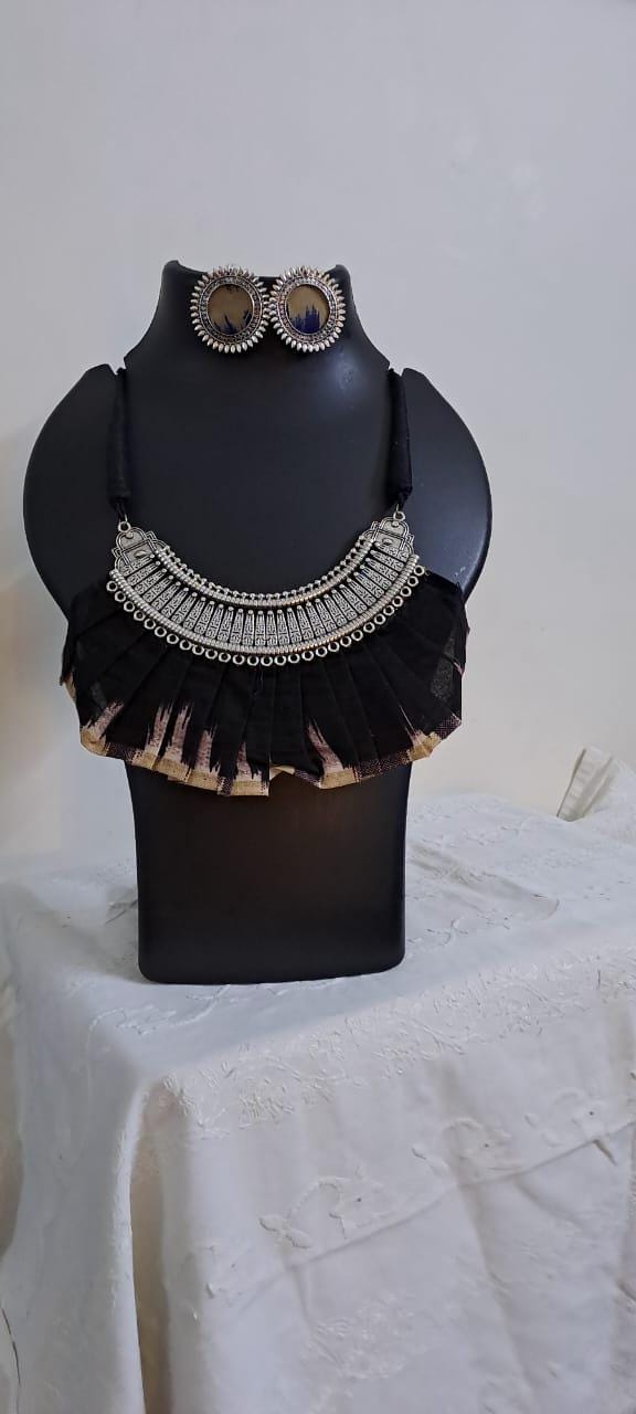 Exclusive necklace with silver oxidised big oval pendant with fabric fringes and matching earrings.