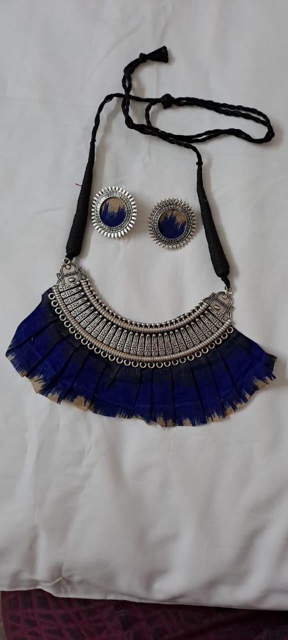 Exclusive necklace with silver oxidised big oval pendant with fabric fringes and matching earrings.