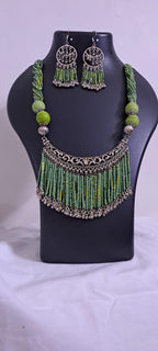 Exclusive necklace with silver oxidised big oval pendant with seed beads fringes and matching earrings.