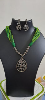 Green thread necklace with silver oxidised traditional pendant