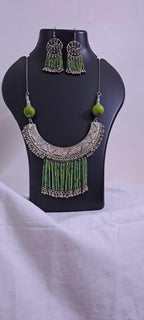 Exclusive necklace with silver oxidised big oval pendant with seed beads fringes and matching earrings.