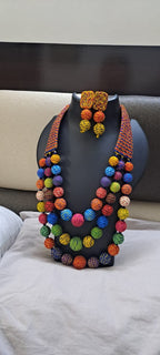 Multi layered and multicoloured necklace with colouful thread ball beads and with matching earrings.
