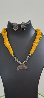 Yellow thread necklace with oxidised silver dokra pendant