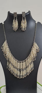 Exclusive layered off white seed beads necklace with matching hanging earrings.