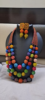 Multi layered and multicoloured necklace with colouful thread ball beads and with matching earrings.