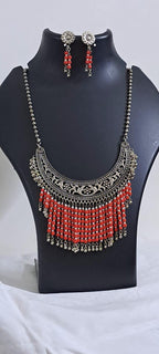 Exclusive necklace with silver oxidised big oval pendant with glass beads fringes and matching earrings.