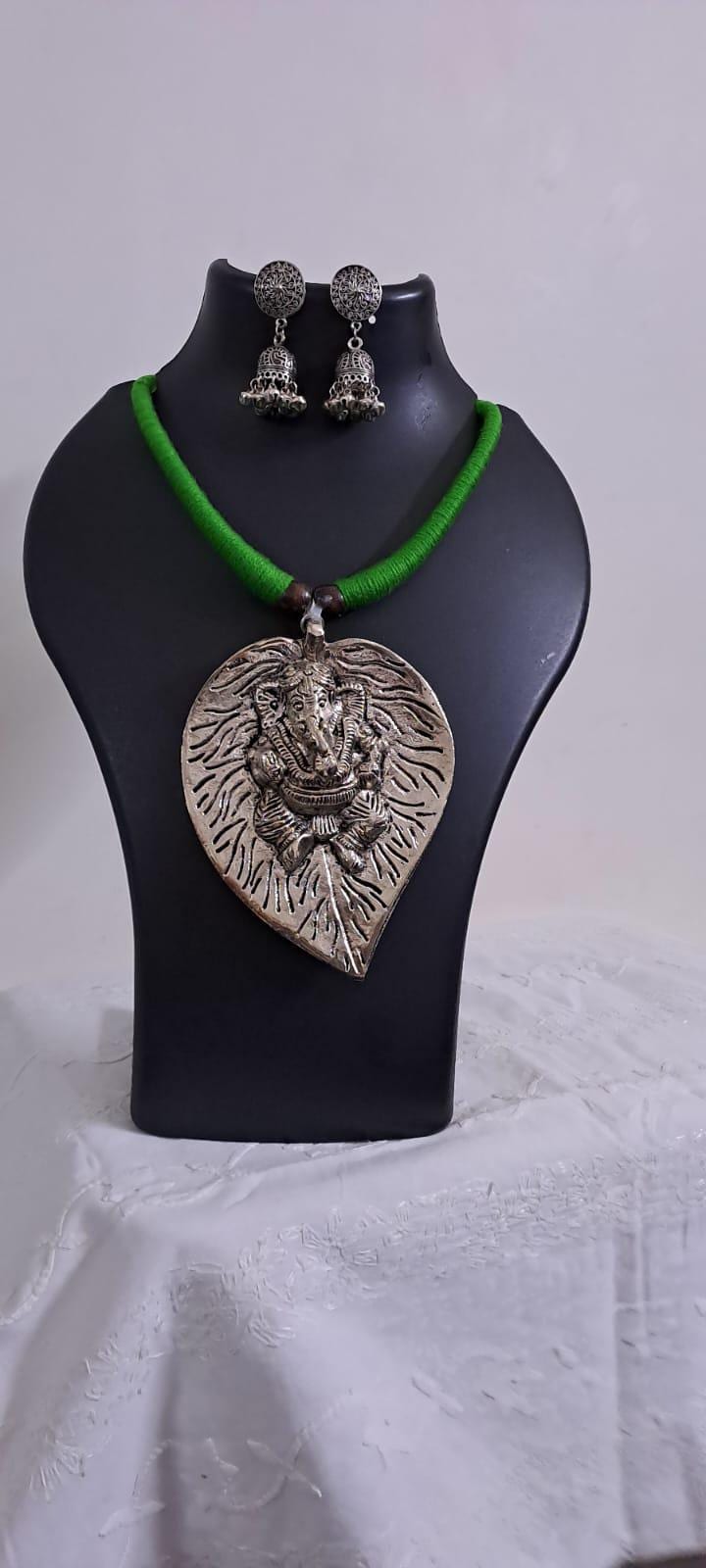 Green thread necklace with silver oxidised ganesha pendant