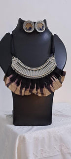Exclusive necklace with silver oxidised big oval pendant with fabric fringes and matching earrings.