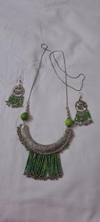 Exclusive necklace with silver oxidised big oval pendant with seed beads fringes and matching earrings.