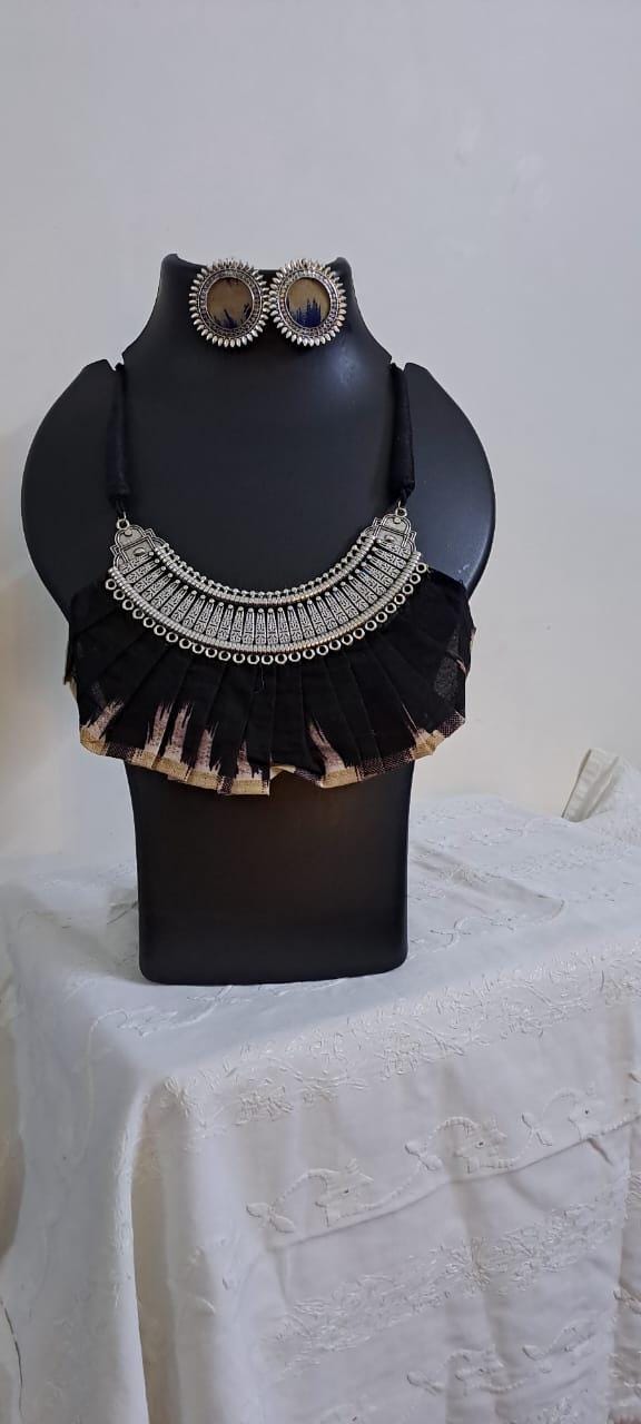 Exclusive necklace with silver oxidised big oval pendant with fabric fringes and matching earrings.
