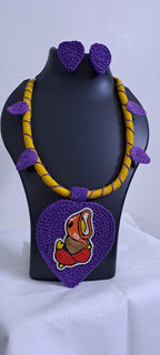 Exclusive yellow and purple thread necklace with leaf shaped  Ganesha thread pendant and matching earrings.